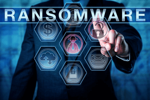 Male cybersecurity threat systems manager pushing RANSOMWARE on a transparent control interface. Computer crime concept for a hacking attack restricting file access to seek a ransom from a user.